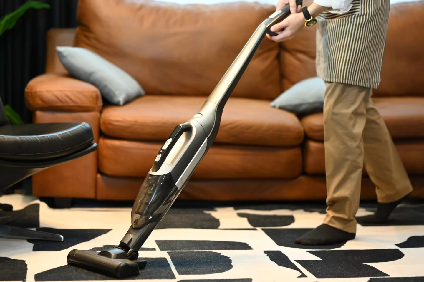 Man using cordless vacuum cleaner to removes germs and dirt on c
