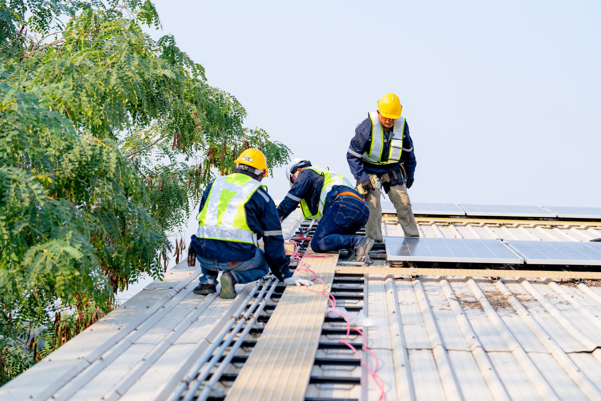 workers installing solar panels, for efficient energy on rooftop